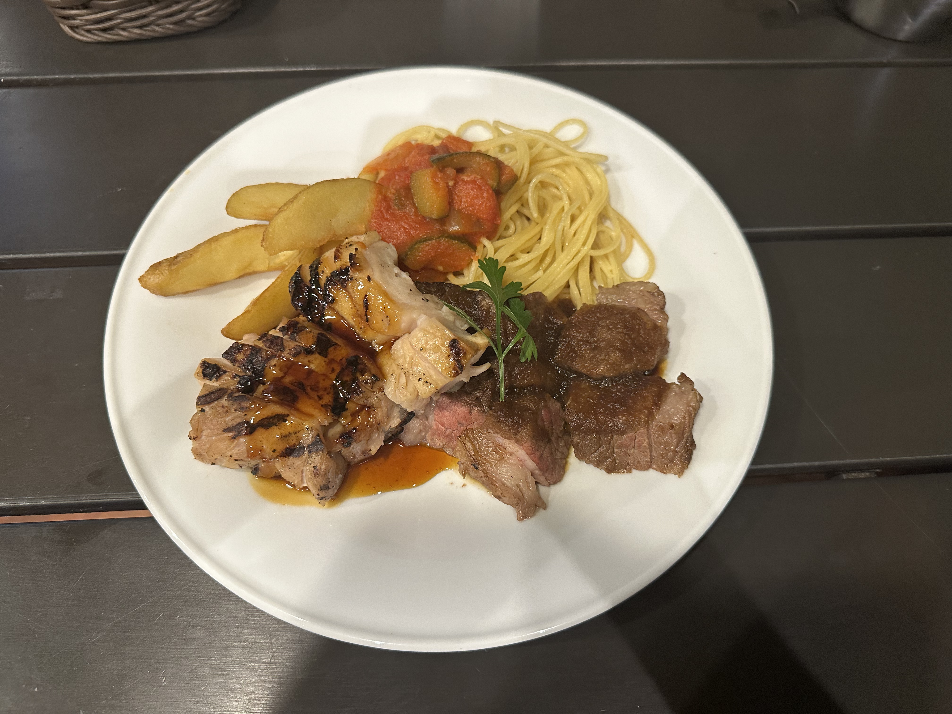 グリルした肉やパスタ、ポテトが盛り付けられた夕食のワンプレート