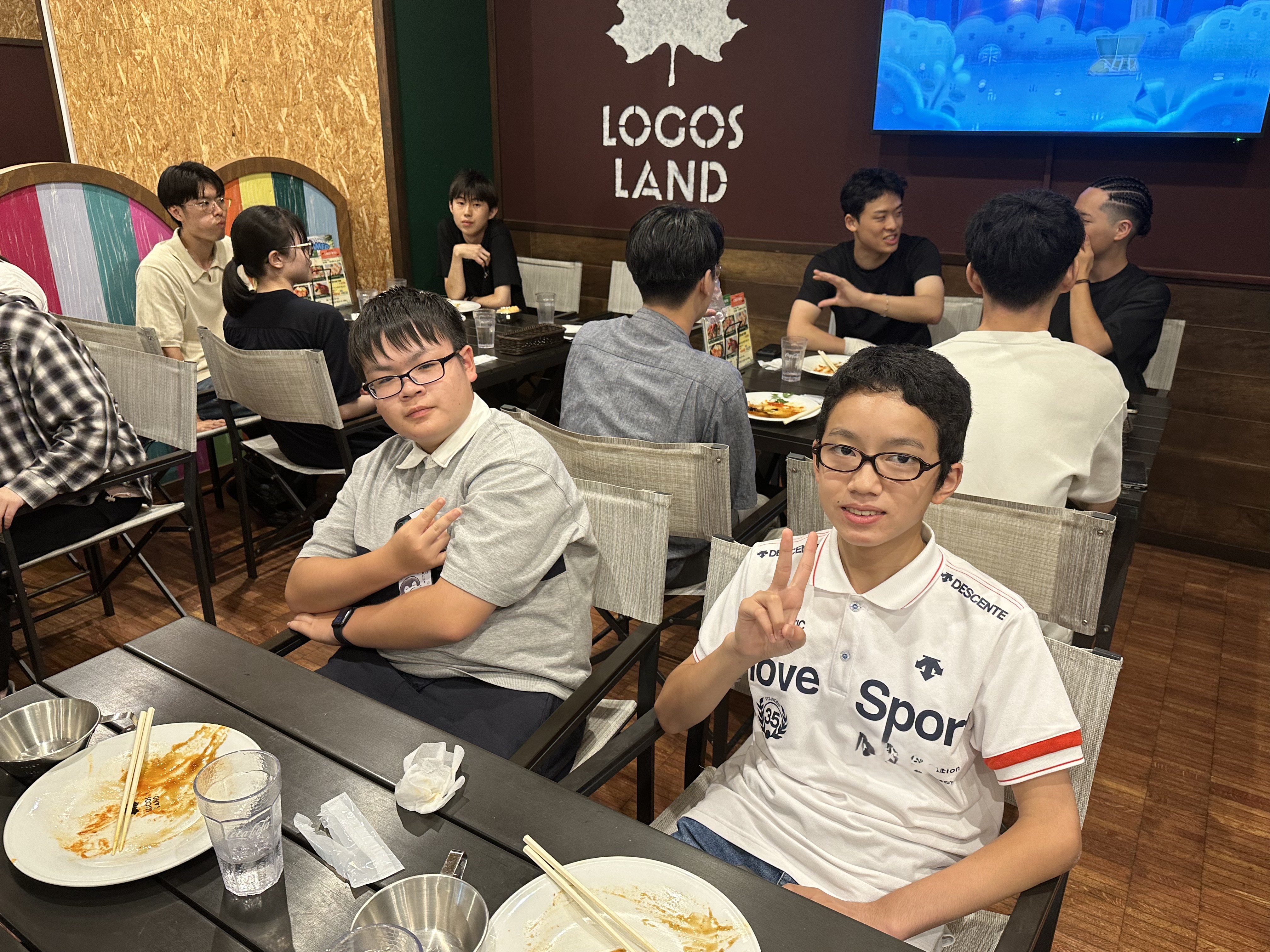 ロゴスランドの食事会場で、食事を終えてピースサインを見せる生徒たち