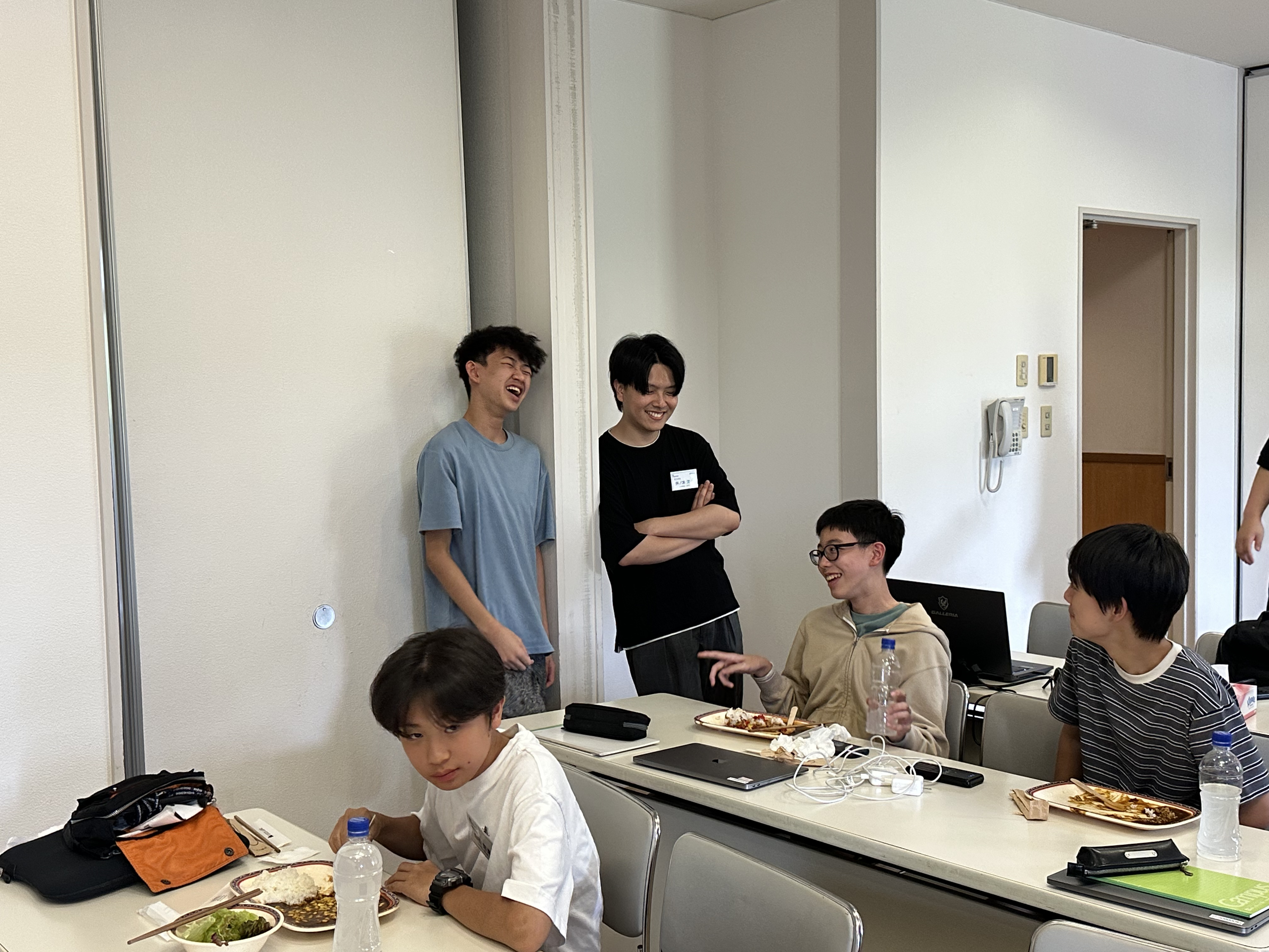 研修室でカレーライスを食べながら談笑する生徒と講師