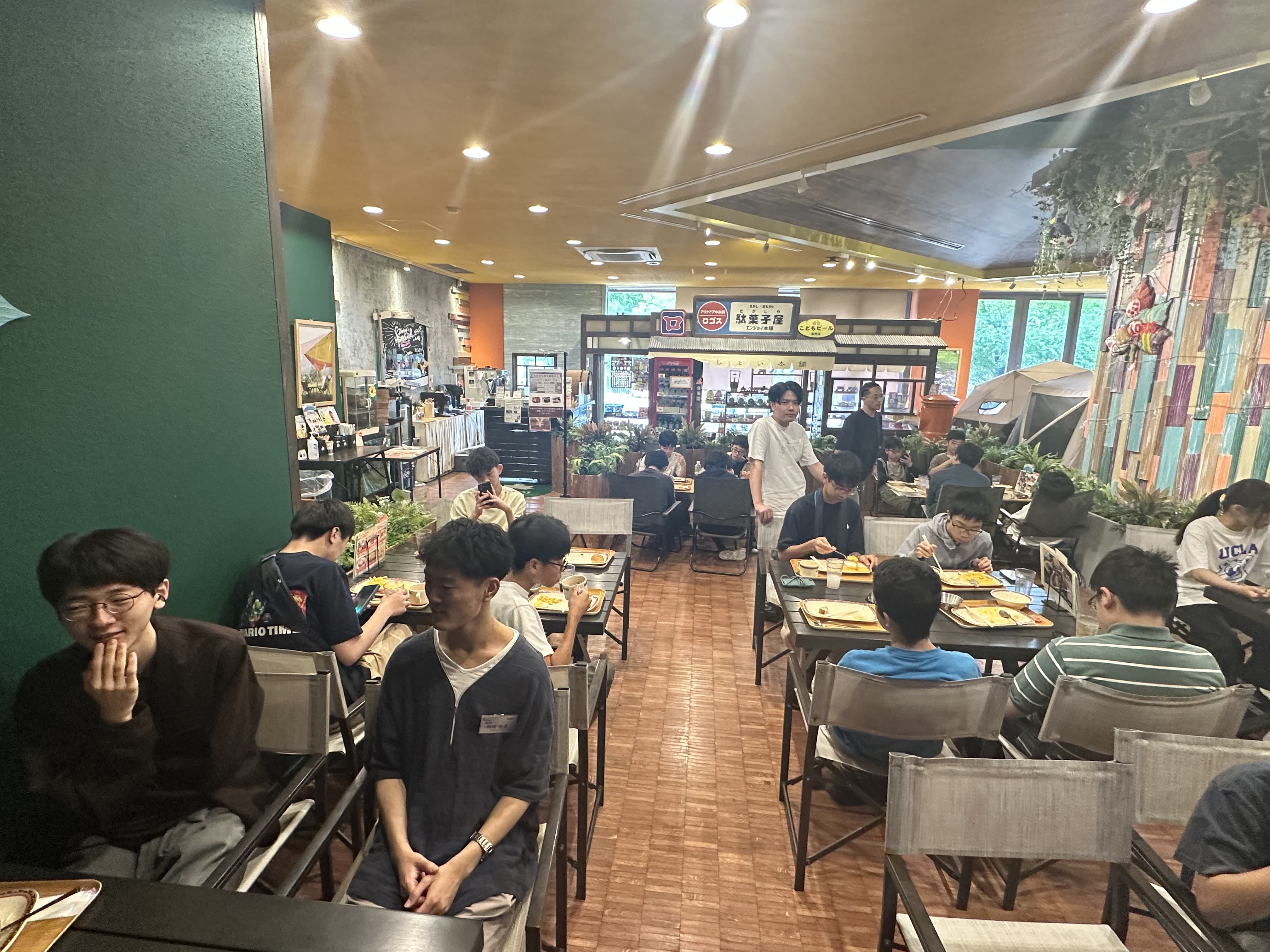 ロゴスランドのレストランでトレイの朝食をとる生徒たち