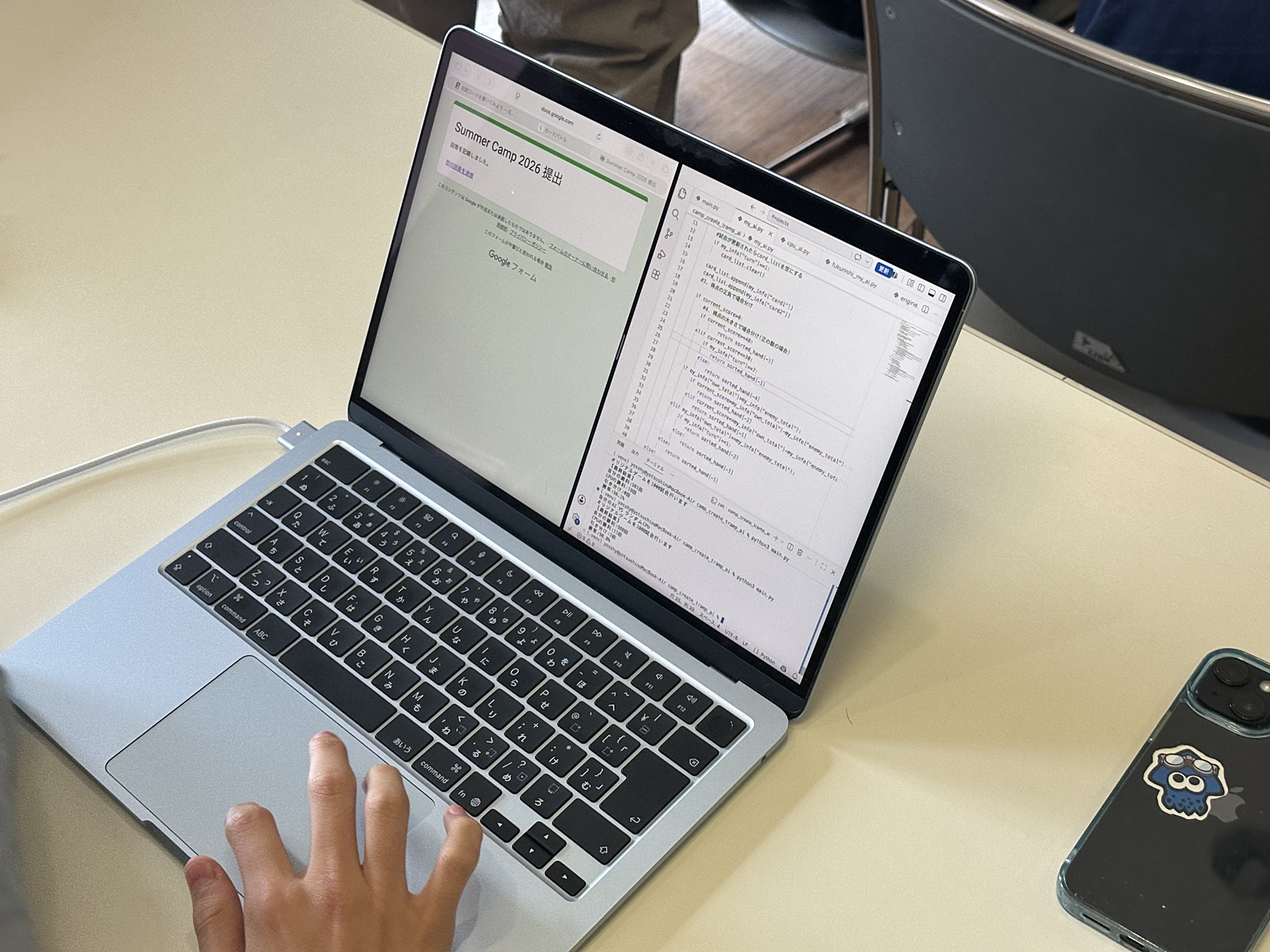 ノートPC画面に表示された提出完了画面と、編集中のAIプログラムのコード
